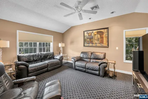 a living room with furniture a large window and a flat screen tv