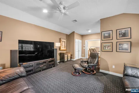 a living room with furniture a flat screen tv and a window