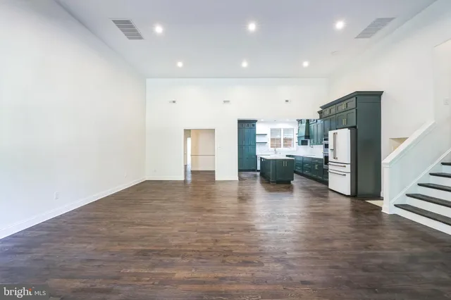 a view of kitchen with refrigerator and wooden floor