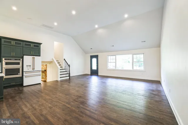 a view of empty room with wooden floor and window