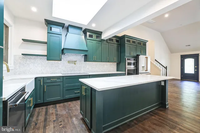 a kitchen with kitchen island a sink stove and cabinets