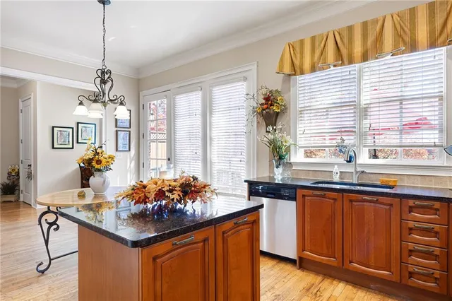 a kitchen with stainless steel appliances kitchen island granite countertop wooden cabinets and dining table