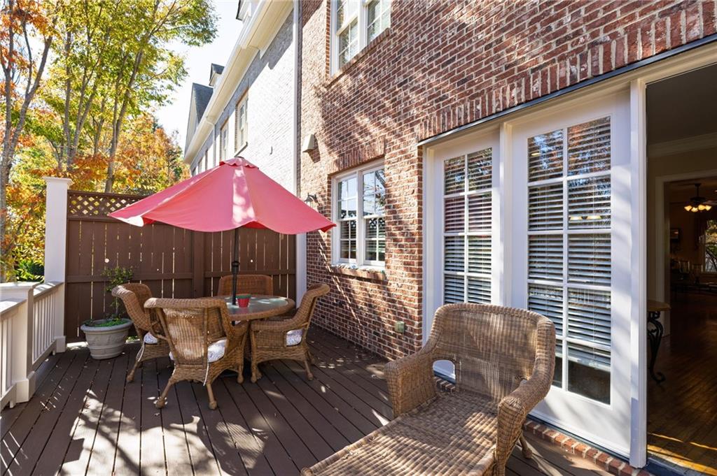 2354 St Davids Square, Unit 3 Kennesaw, GA 30152 - Photo 22 of 39 a view of a patio with a dining table and chairs under an umbrella with wooden fence