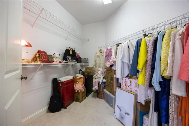 a view of walk in closet with clothes and shoes