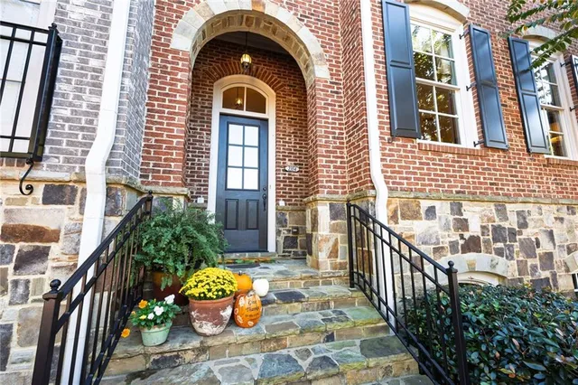 a view of a brick house with many windows and plants