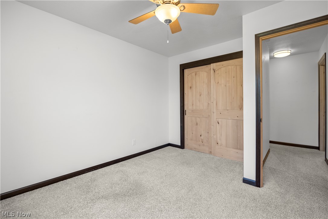 6760 Mason Road Berlin Heights, OH 44814 - Photo 23 of 49 Unfurnished bedroom with carpet flooring, a closet, and a ceiling fan