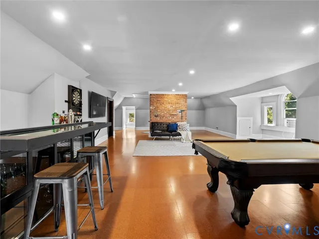 a room with wooden floor table and chairs