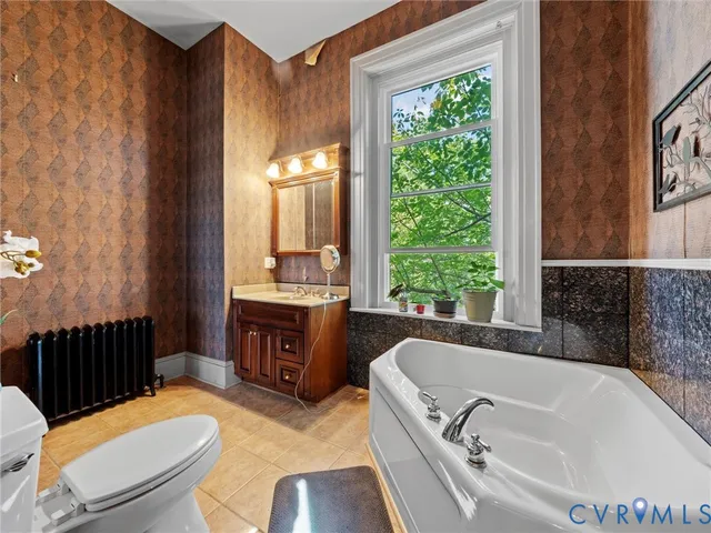 a bathroom with a granite countertop toilet a sink and a bathtub