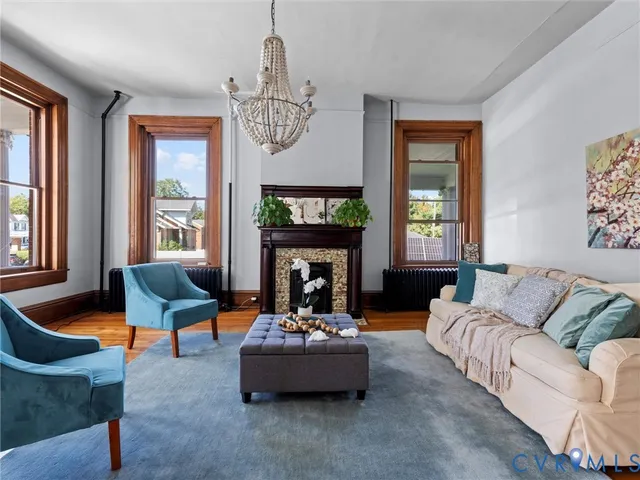 a living room with fireplace furniture and a large window