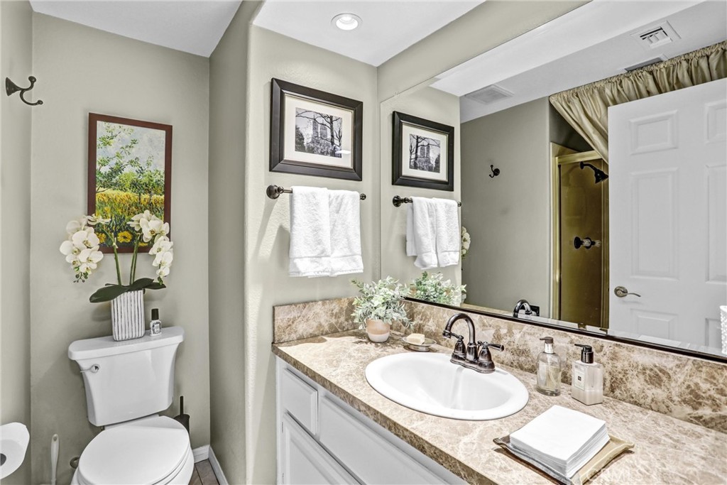 5787 Ridgeway Road Rancho Cucamonga, CA 91701 - Photo 25 of 56 a bathroom with a granite countertop sink and a toilet