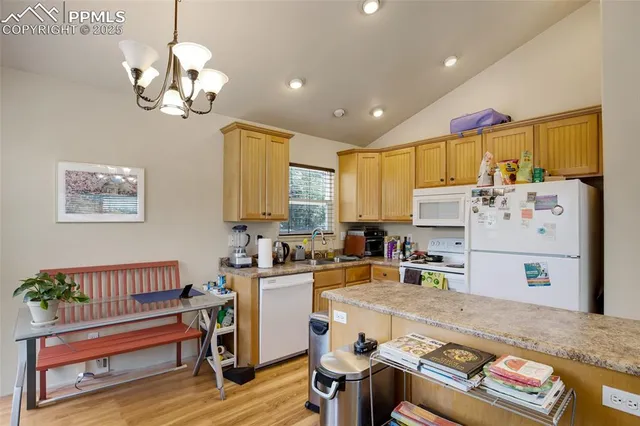 a room with furniture a chandelier and a view of kitchen