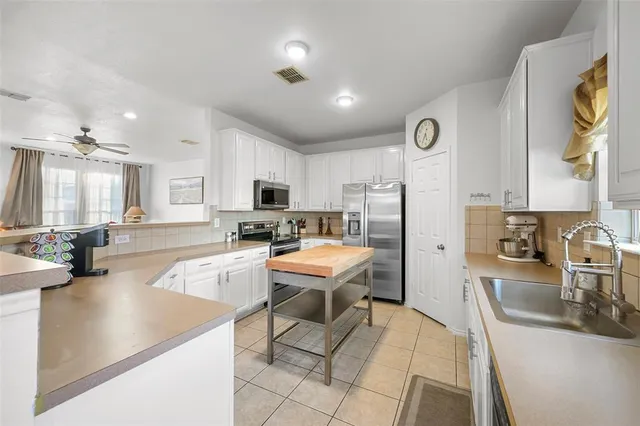 a kitchen with stainless steel appliances granite countertop a sink a stove and a refrigerator