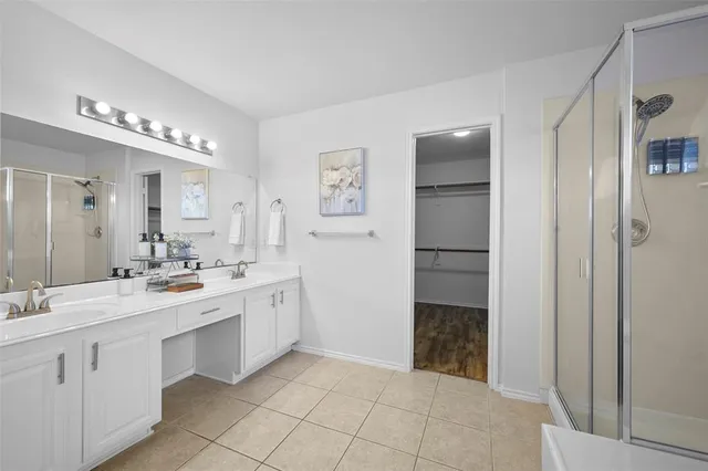 a spacious bathroom with a double vanity sink and a mirror