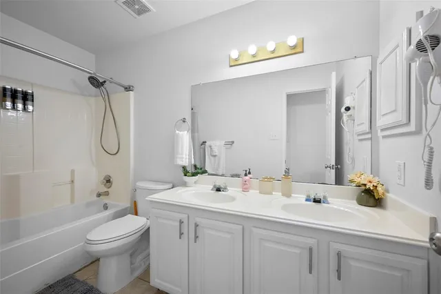 a bathroom with a granite countertop sink a toilet and shower