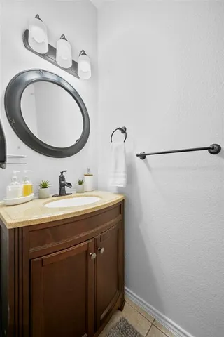 a bathroom with a granite countertop sink and a mirror