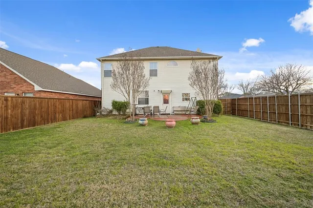 a backyard of a house with table and chairs