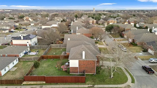 an aerial view of residential houses with outdoor space and trees