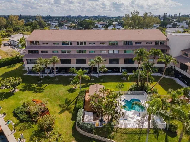 an aerial view of a house with a swimming pool a yard and a patio