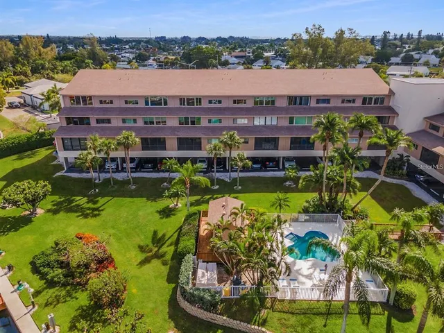 an aerial view of a house with a garden and lake view