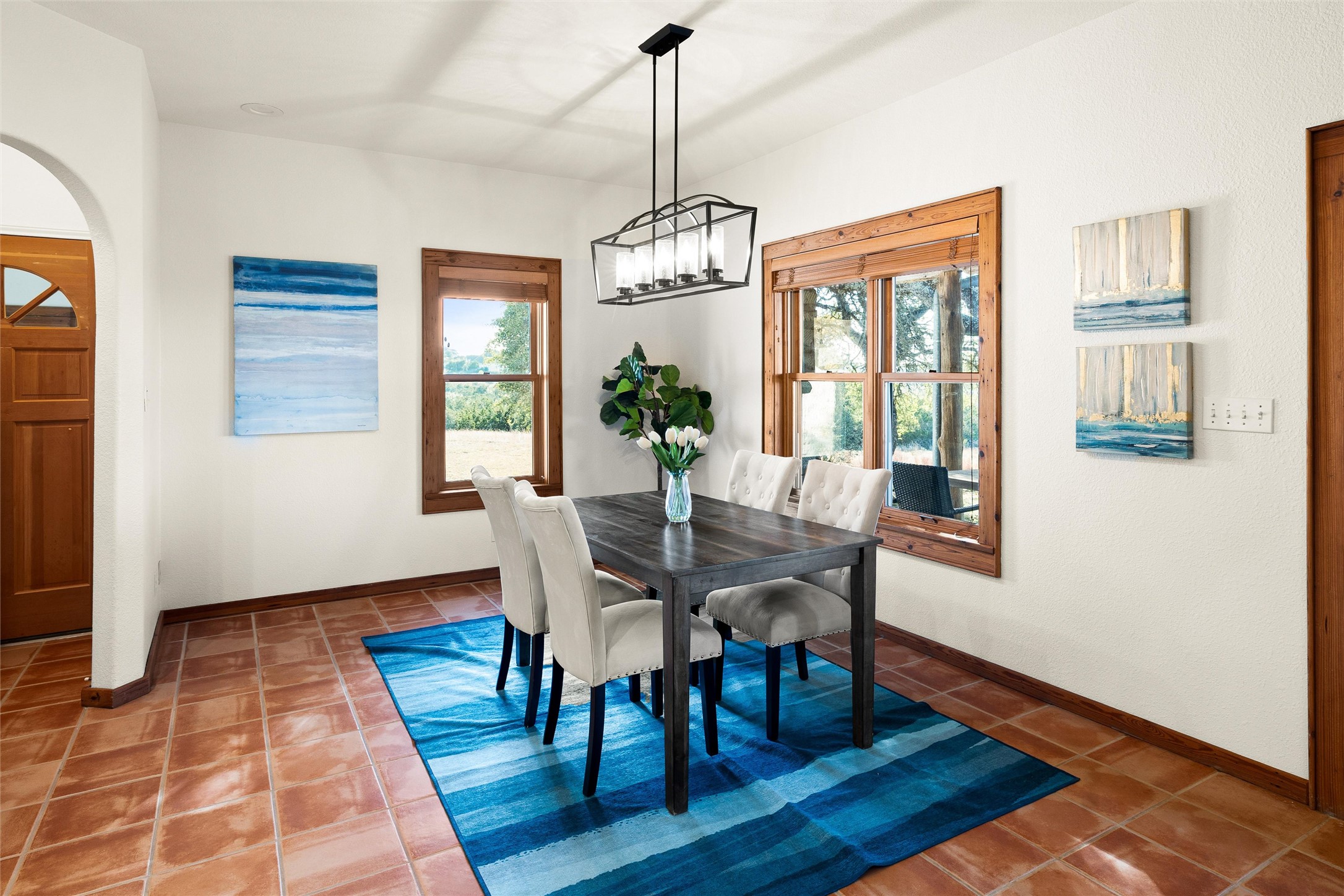 300 Sundown Ridge Austin, TX 78737 - Photo 18 of 40 a dining room with wooden floor a chandelier a wooden table and chairs