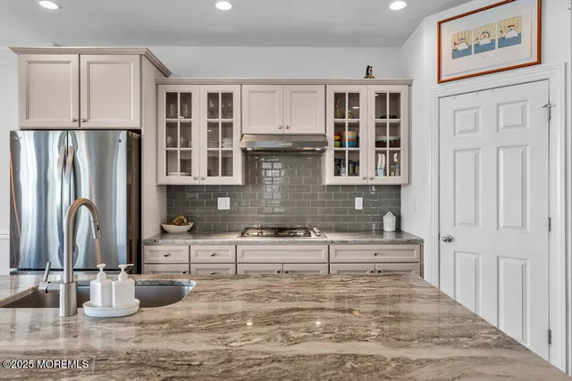 a kitchen with stainless steel appliances granite countertop a sink stove and refrigerator