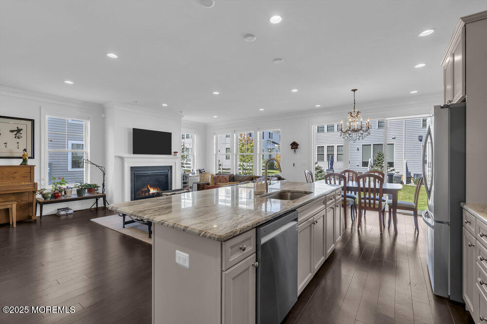 26 Malcolm Way Lincroft, NJ 07738 - Photo 20 of 44 a kitchen with stainless steel appliances granite countertop a stove top oven a sink a dining table and chairs with wooden floor