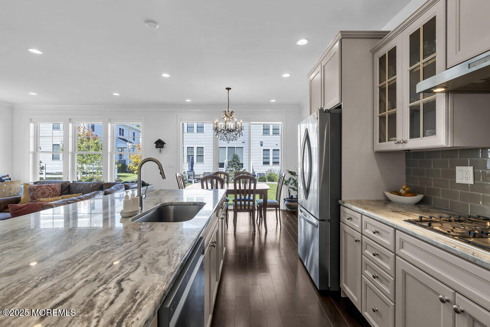 26 Malcolm Way Lincroft, NJ 07738 - Photo 21 of 44 a kitchen with stainless steel appliances granite countertop a refrigerator a stove and a sink with wooden cabinets