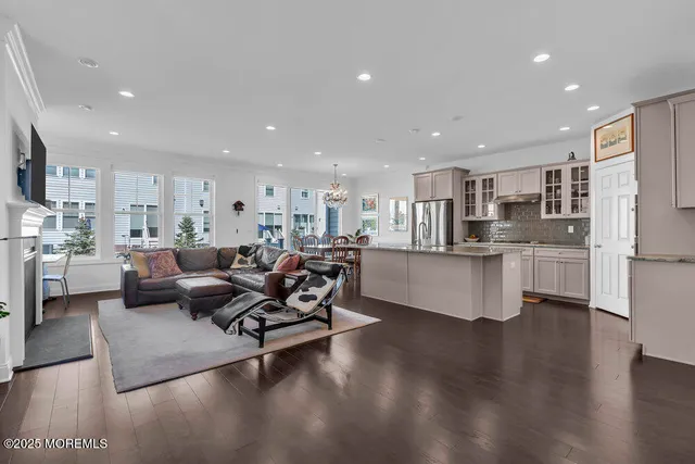 a living room with stainless steel appliances kitchen island granite countertop a couch and a view of kitchen