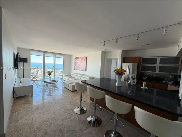 a kitchen with stainless steel appliances granite countertop a sink refrigerator and microwave