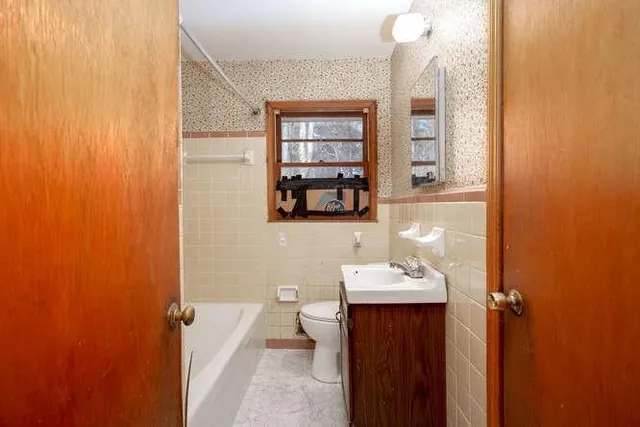 a bathroom with a sink a toilet and mirror