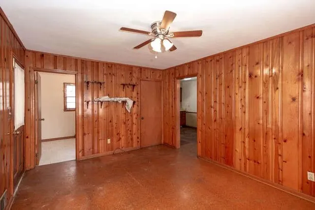 a view of empty room with wooden floor and ceiling fan