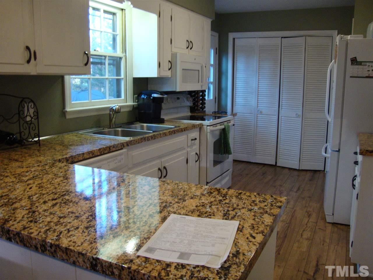Kitchen with renewed counters, removed partial wall to make it more open.  New sink, cabinet hardware, appliances, and floor.