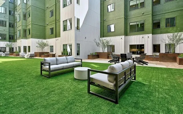 a view of a house with backyard and sitting area