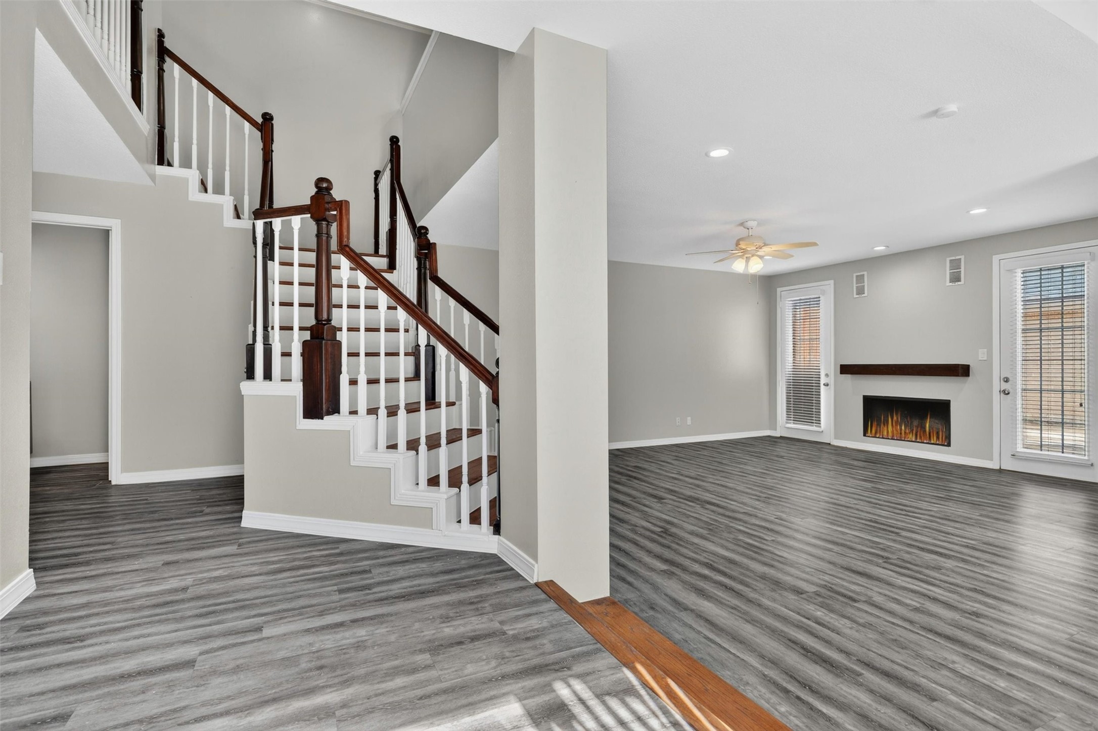 12929 Kingsbridge Lane Houston, TX 77077 - Photo 5 of 42 Step into a bright and inviting interior featuring soaring ceilings, elegant staircase details, and an open-concept layout designed for modern living. This beautifully updated space showcases luxury-style flooring, abundant natural light, and a sleek contemporary fireplace that creates the perfect focal point for entertaining or relaxing. Buyers will love the spacious feel, neutral designer colors, and seamless flow throughout the home.