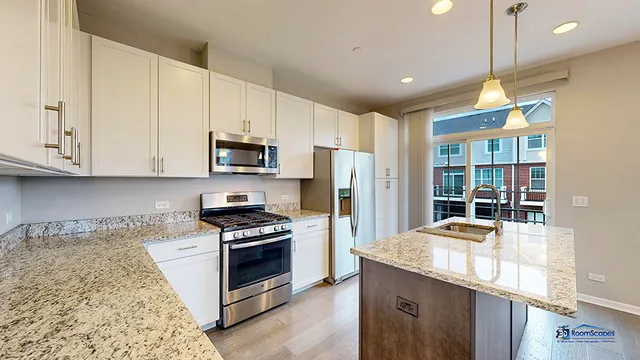 a kitchen with granite countertop a stove a sink a refrigerator and a microwave