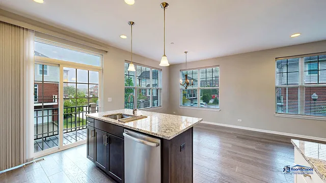 a open kitchen with granite countertop a sink and wooden floor