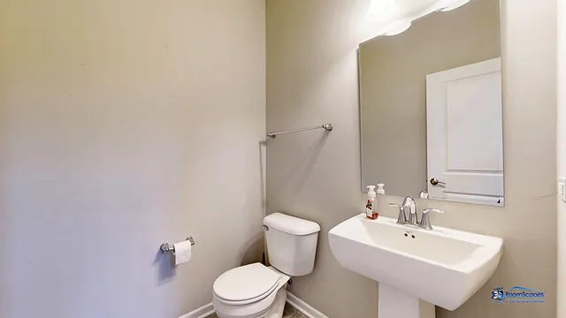 a bathroom with a sink mirror and toilet