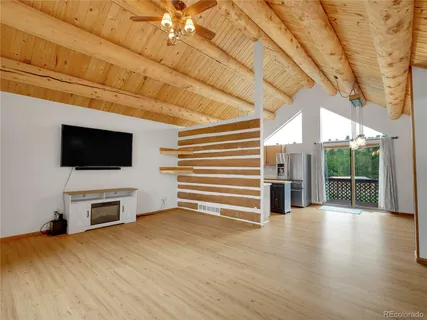a view of a livingroom with wooden floor and a flat screen tv