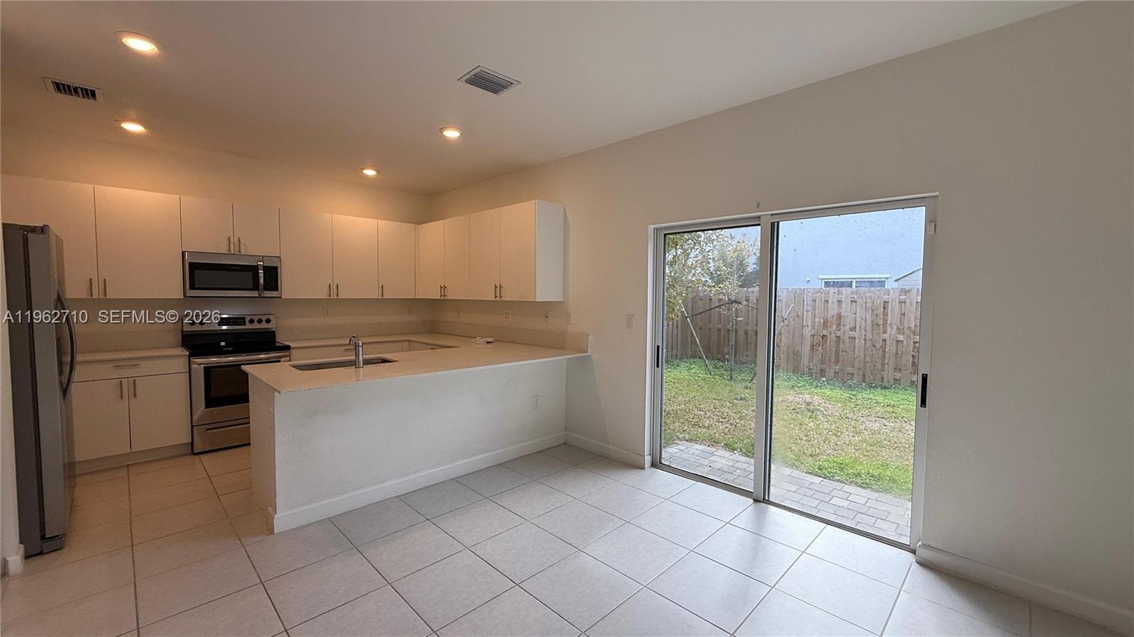 16244 Southwest 291st Street, Unit 16244 Homestead, FL 33033 - Photo 12 of 49 a large kitchen with a large window and white stainless steel appliances