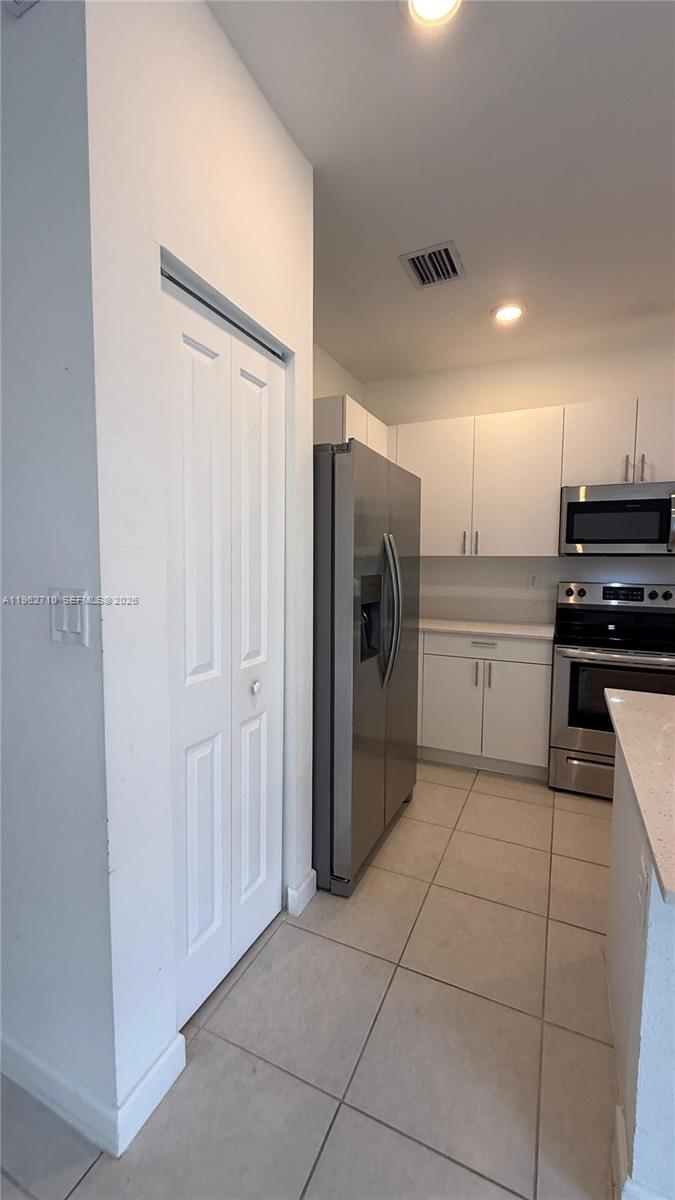 16244 Southwest 291st Street, Unit 16244 Homestead, FL 33033 - Photo 15 of 49 a kitchen with a refrigerator and white cabinets