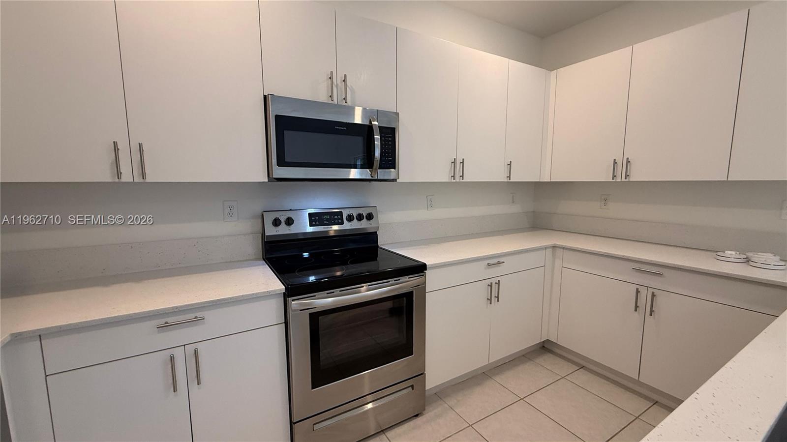 16244 Southwest 291st Street, Unit 16244 Homestead, FL 33033 - Photo 18 of 49 a kitchen with white cabinets and stainless steel appliances