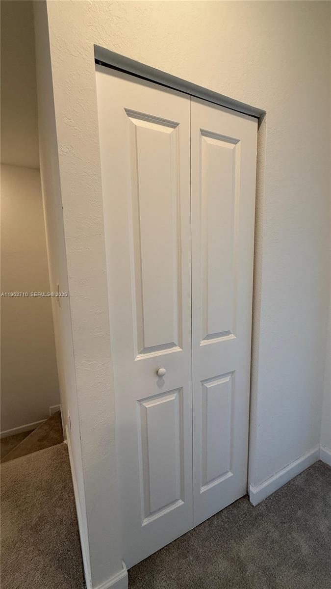 16244 Southwest 291st Street, Unit 16244 Homestead, FL 33033 - Photo 24 of 49 an empty room with a wooden door