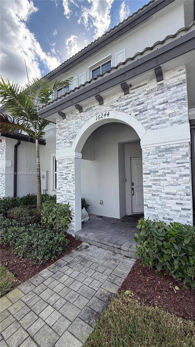 16244 Southwest 291st Street, Unit 16244 Homestead, FL 33033 - Photo 3 of 49 a stone house with a outdoor space