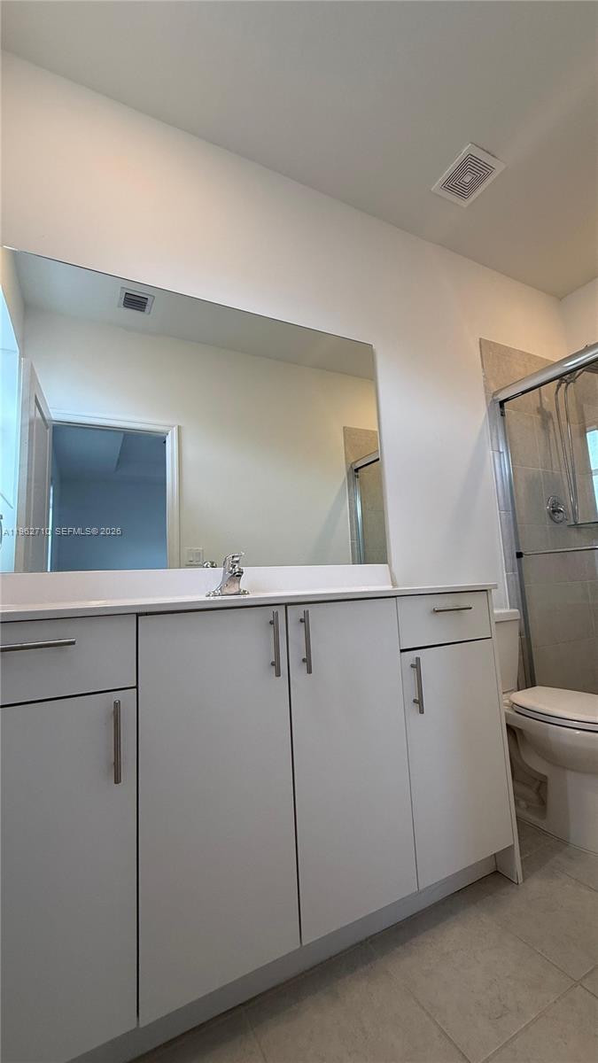 16244 Southwest 291st Street, Unit 16244 Homestead, FL 33033 - Photo 45 of 49 a bathroom with a toilet sink and mirror