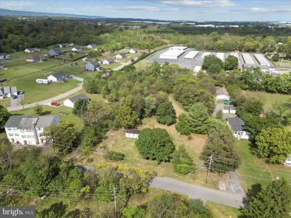 an aerial view of residential houses with outdoor space and trees