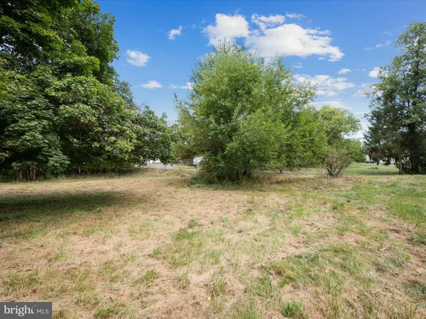 a view of a green field with wooden fence
