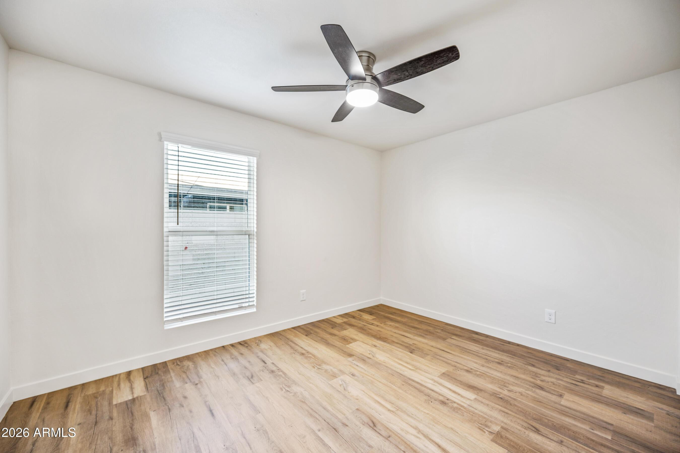 4139 North 27th Street, Unit 4 Phoenix, AZ 85016 - Photo 18 of 29 an empty room with wooden floor fan and windows