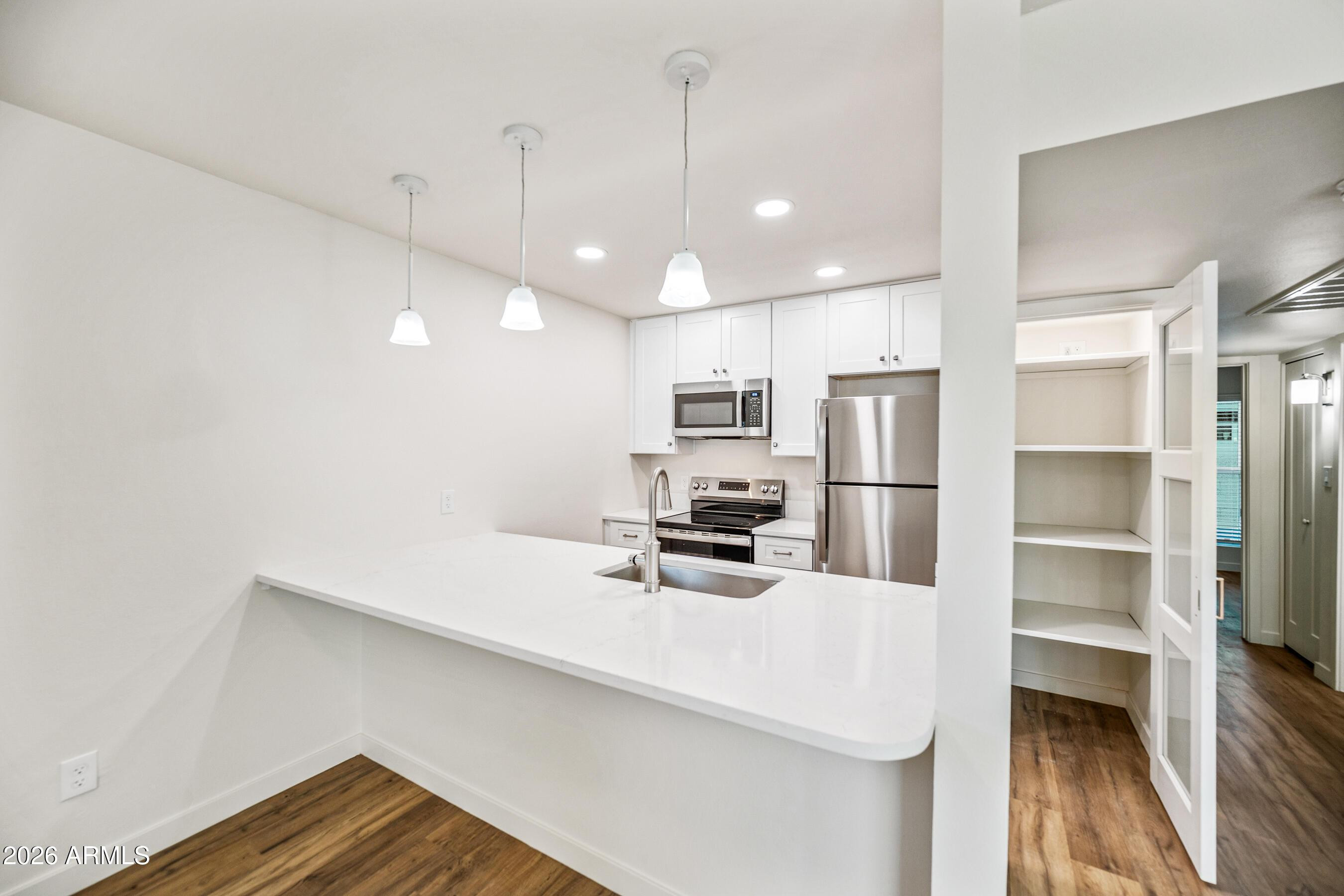 4139 North 27th Street, Unit 4 Phoenix, AZ 85016 - Photo 8 of 29 a kitchen with stainless steel appliances a refrigerator and microwave