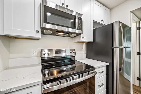 a kitchen with stainless steel appliances granite countertop a stove microwave and refrigerator