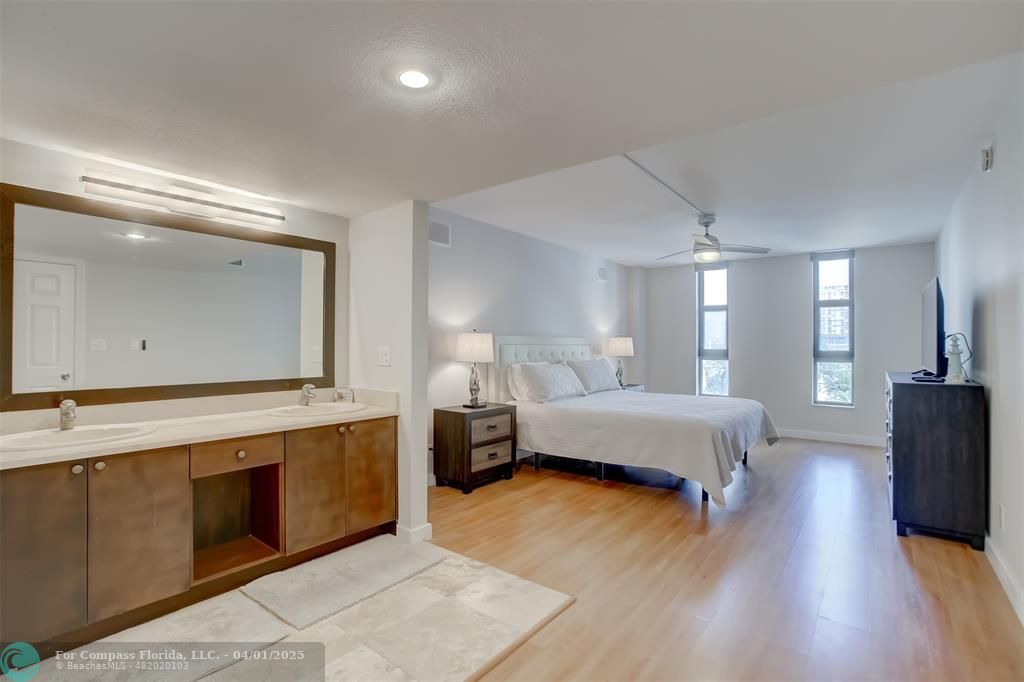 1000 South Ocean Boulevard, Unit 5O Pompano Beach, FL 33062 - Photo 17 of 42 a spacious bedroom with a bed and a dresser with wooden floor
